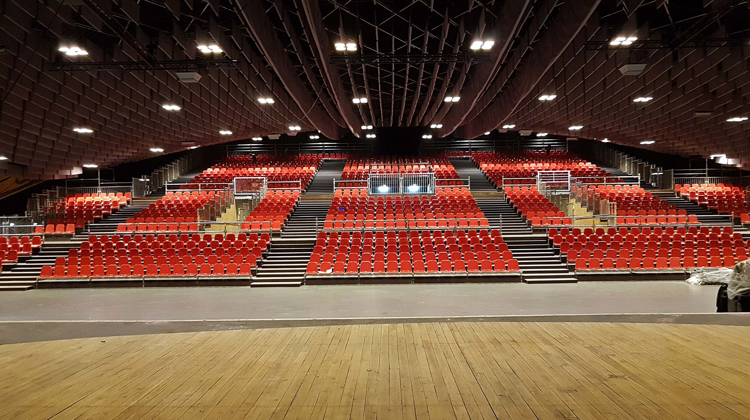 Création d’une tribune de 1900 places minimum dans la salle Robert Hossein, Lourdes, avec une accessibilité confortable aux personnes à mobilité réduite et fauteuils roulant.